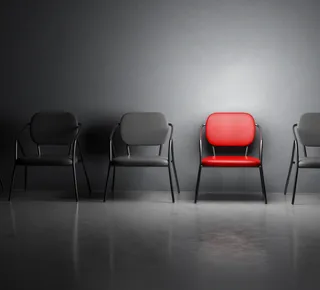 Red Chair in a line of black chairs